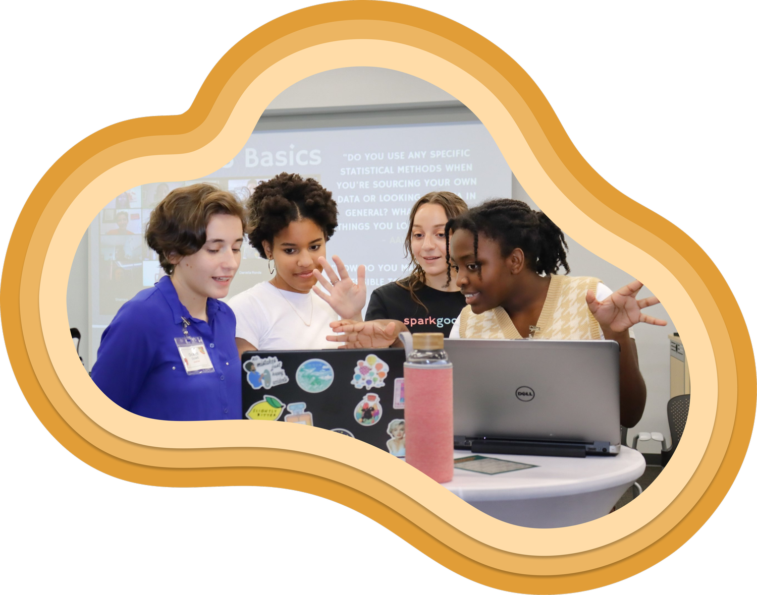 Diverse group of trubel&co students collaborating around a laptop during an impact-focused STEM session.